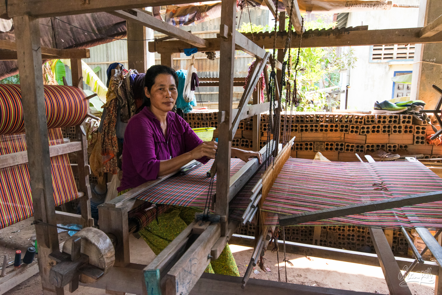 Une jolie tisserande des îles de la soie en plein travail sur son métier à tisser