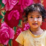 Petite Khmer Devant La Tenture Du Magasin De Ses Parents